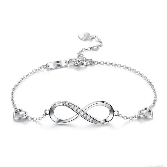 Silver infinity bracelet with sparkling stones, featuring two heart accents and a delicate chain, marked with "S925" for quality.