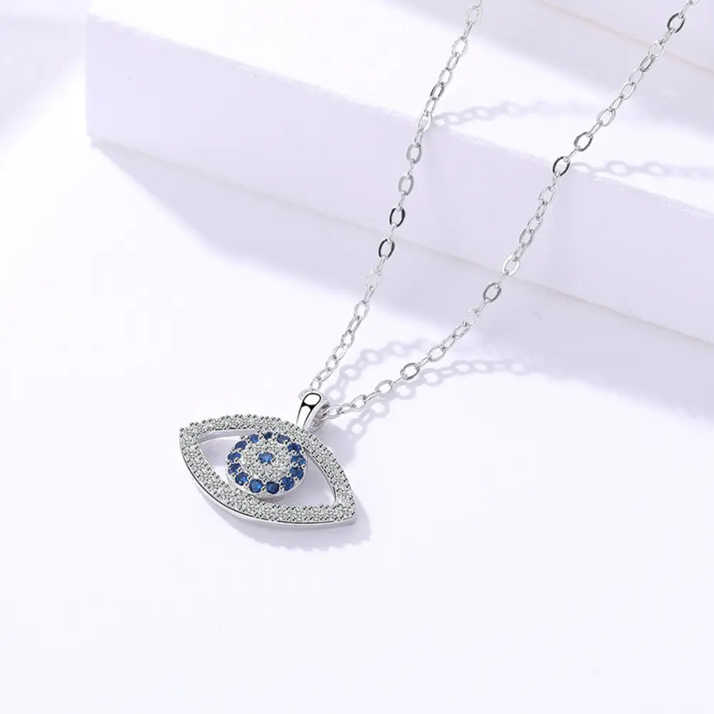 Silver chain necklace featuring an eye-shaped pendant with blue and white gemstones, symbolizing protection and elegance.