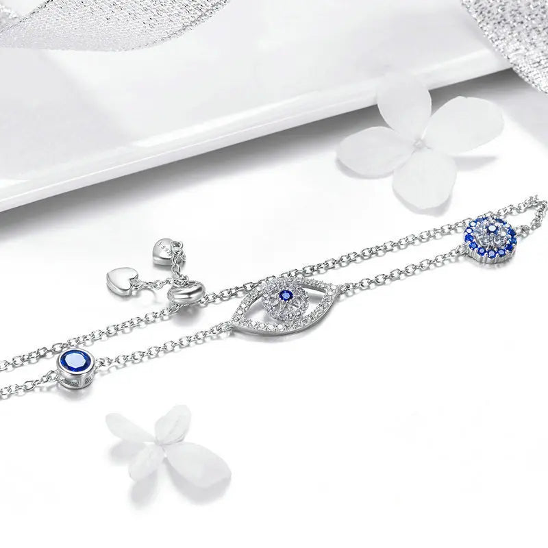 Silver bracelets with blue gemstones on a white surface