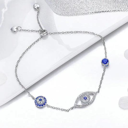 Silver bracelet with blue gemstones on a white surface