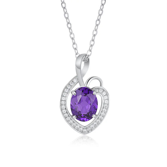 A silver heart-shaped pendant adorned with a large oval purple gemstone, surrounded by small sparkling stones, on a delicate chain.